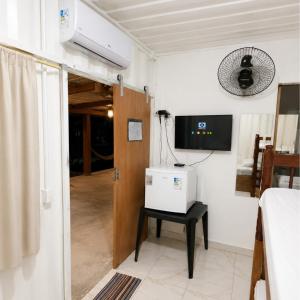 a room with a door and a table with a television at Pousada Rancho Texas Ubatuba in Ubatuba