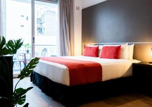a bedroom with a large bed with red pillows at Reco by DOT Suites in Buenos Aires +28 photos