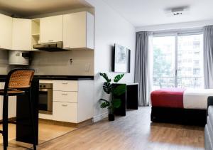 a bedroom with a bed and a kitchen with a table at Reco by DOT Suites in Buenos Aires