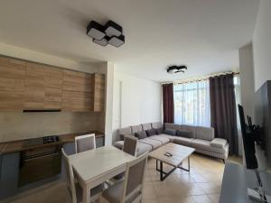 a living room with a couch and a table at Near movenpic apartament in Draç