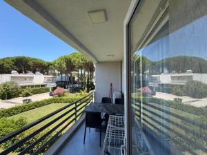 a balcony with a table and chairs looking out at the yard at Near movenpic apartament in Draç