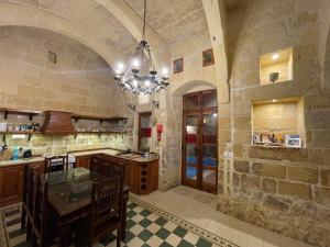 a large kitchen with a chandelier in a building at Kercem Boutique Farmhouse in Kerċem