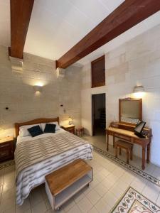 a bedroom with a bed and a desk and aaptop at Kercem Boutique Farmhouse in Kerċem