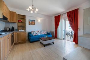 a kitchen and a living room with a blue couch at Haraki Bay Hotel and Luxury Apartments in Haraki
