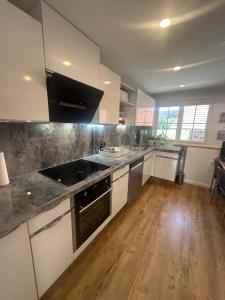 a large kitchen with white cabinets and a wooden floor at Haus am Murgtalpfad 1 und 2 in Rickenbach