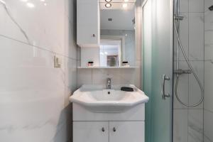 a white bathroom with a sink and a shower at Haraki Bay Hotel and Luxury Apartments in Haraki +56 photos