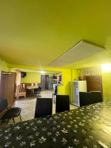 a room with a table and chairs and a kitchen at Cabana Adelin in Dobreşti