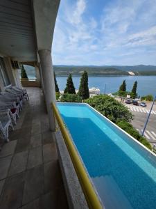 a pool on the balcony of a building with a view of the water at Hotel Stella in Neum