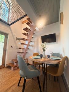 a dining room with a table and a spiral staircase at Tiny Folk in Gărâna