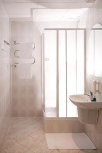 biała łazienka z umywalką i prysznicem w obiekcie Hotel Albatros w mieście Przemyśl