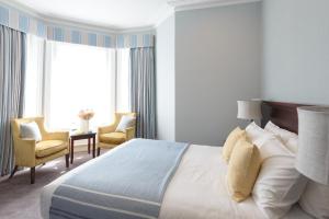 a bedroom with a large bed and two chairs at Connaught Lodge in Bournemouth +35 photos