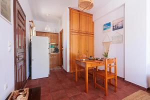 eine Küche mit einem Holztisch und einem Kühlschrank in der Unterkunft Sunblaze Studios1 Spetses in Spetses