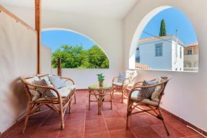 eine Terrasse mit Stühlen, einem Tisch und einem Fenster in der Unterkunft Sunblaze Studios1 Spetses in Spetses