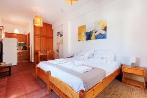 ein Schlafzimmer mit einem großen Bett mit weißer Bettwäsche in der Unterkunft Sunblaze Studios1 Spetses in Spetses