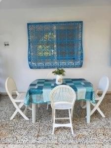 a dining room table with chairs and a blue and white table at summer kif in Nabeul
