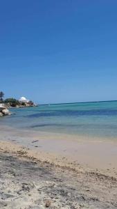 a sandy beach with the ocean in the background at summer kif in Nabeul