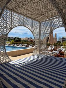 a view of a swimming pool and ailion with chairs and umbrellas at Lux Hotel M - Boutique Hotel & Restaurant in Dobra Voda