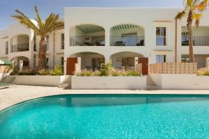 a villa with a swimming pool in front of a building at Inturotel Esmeralda Villas in Cala d´Or