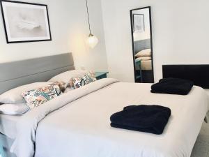 two beds in a bedroom with black towels on them at Derbyshire House Apartment 3 - Cavendish in Buxton