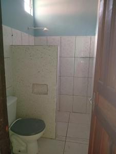 a bathroom with a toilet and a tiled wall at Pousada Don Melo in Salvaterra +9 photos