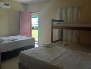 a bedroom with two beds and a door to a yard at Pousada Don Melo in Salvaterra
