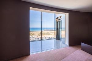 a room with a large window with a view of the ocean at Hotel Natura Park in Comarruga