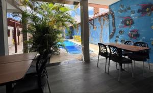 a dining room with a table and chairs and a pool at Pousada Solare in Maragogi