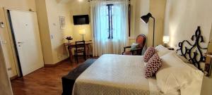 a bedroom with a bed and a room with a desk at Casa Becci Central Bright & Cozy Flat in San Gimignano