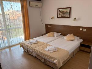 a bedroom with a bed and a large window at Family Hotel Verona in Sozopol