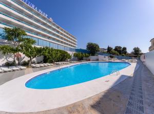 an empty swimming pool in front of a building at Hotel Natura Park in Comarruga +10 photos