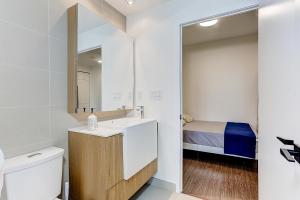 a bathroom with a sink and a toilet and a bed at Lakeview 1 Bed 1 Den by Rogers Centre in Toronto +44 photos