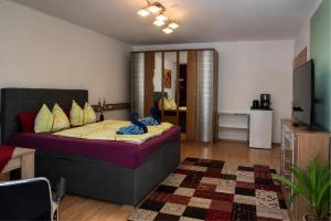 a bedroom with a bed and a living room at Hotel Garni in Burghausen