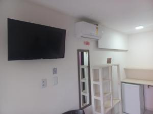 a living room with a flat screen tv on a wall at AYRE GOSTOSO POUSADA in São Miguel do Gostoso