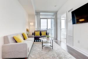 a living room with a couch and a table at Lakeview 1 Bed 1 Den by Rogers Centre in Toronto