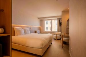 a hotel room with a bed and a window at The CORNR Seaview in Nieuwpoort