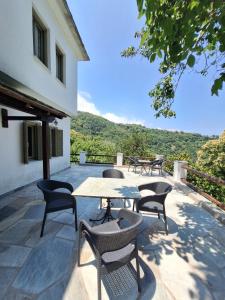 a patio with a table and chairs and a view at Deluxe house in Tsangarada in Tsagarada