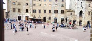 a group of people walking in front of a building at Casa Becci Central Bright & Cozy Flat in San Gimignano +3 photos