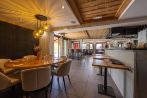 a restaurant with a table and chairs and a bar at Le Flocon d'Argent in Les Gets