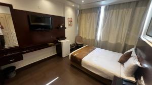 ein Hotelzimmer mit Bett und Flachbildfernseher in der Unterkunft Le Marly Hotel in Beirut