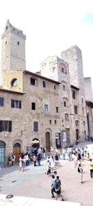 a group of people sitting in front of a large building at Casa Becci Central Bright & Cozy Flat in San Gimignano