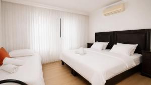 a bedroom with two beds with white sheets at אחוזת החושן - וילה מהממת עם בריכה פרטית in Tirosh