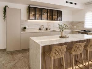 a kitchen with a large island with stools at אחוזת החושן - וילה מהממת עם בריכה פרטית in Tirosh