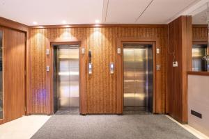 a elevator lobby with three elevators in a building at Treebo Premium Merrit in Katrab