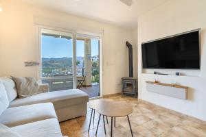 a living room with a couch and a flat screen tv at Bellavista Los Pinos in Almuñécar