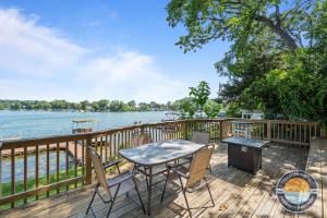 a table and chairs on a deck next to the water at 405 Waldeck Dr in Twin Lakes