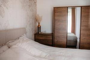 a bedroom with a bed and a dresser and a mirror at Panorama Silva in Augustów