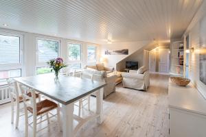 a kitchen and living room with a table and chairs at Haus Strandkind in Sylt
