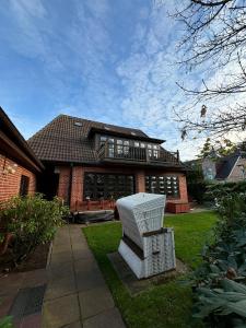 a white chair sitting in front of a house at Haus Strandkind in Sylt