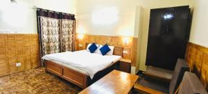 a room with a bed and a table and a tv at The Lake BnB in Nainital +24 photos