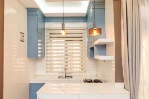 a kitchen with a sink and blue cabinets and a window at Ruts Golden Homes in Kampala +72 photos